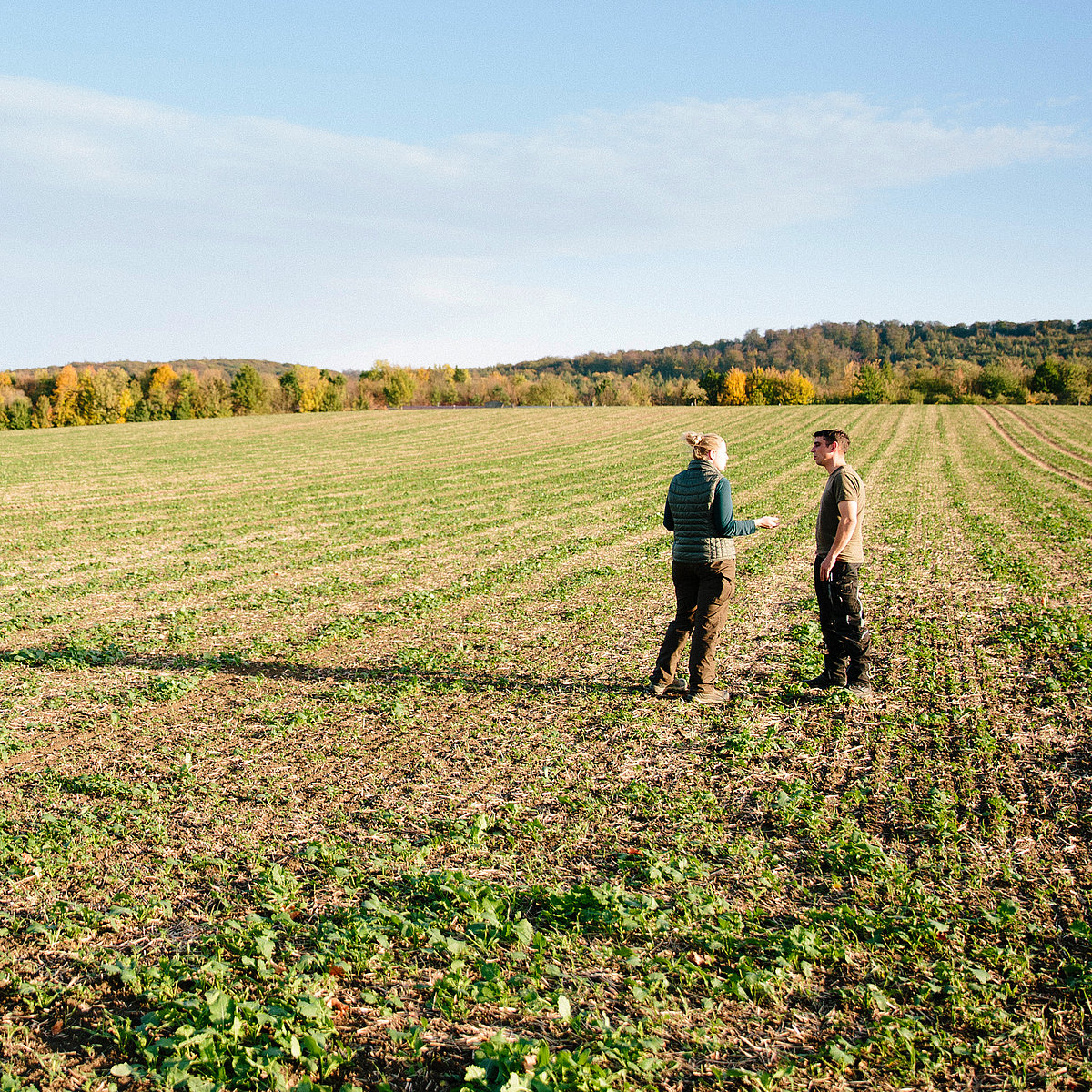 Vom Ersteinsatz Ihrer neuen Maschine bis hin zum Support gut beraten. Zwei Personen besprechen sich auf dem Feld