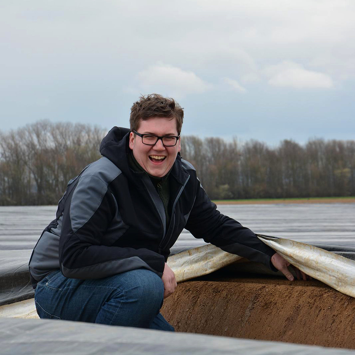 Wenn Sie auch mit der Natur anstatt gegen Sie arbeiten möchten. Spinatbauer hält Plane über dem Beet